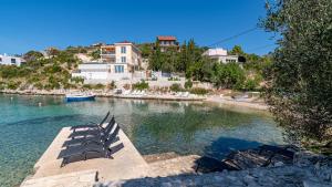 a group of chairs sitting on a dock in the water at Villa Naty with Whirlpool by Villas Guide in Vela Luka