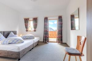 ein Schlafzimmer mit zwei Betten, einem Stuhl und einem Fenster in der Unterkunft Zischgalm in Obereggen