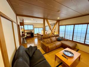 a living room with a couch and a table at Edo-Ko House in Myoko