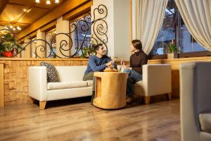 two women sitting at a table with glasses of wine at Hotel La Serenella in Moena +104 photos
