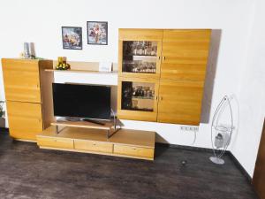 a living room with a tv and a wooden entertainment center at Ferienwohnung Seidl in Waffenbrunn