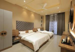a bedroom with a large bed and a television at Hotel Black Harbour - A Unit of Om Shanti Inn in Bharatpur
