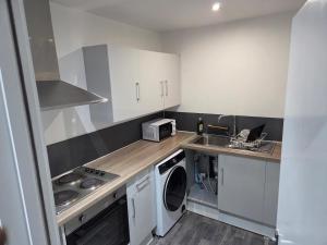 a small kitchen with a washer and a sink at Modern 1-Bed in Wolverhampton City Centre in Wolverhampton