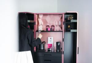 a woman is holding a wine glass in a cabinet at Fauchon l'Hôtel Paris in Paris