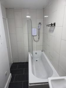 a bathroom with a shower and a tub and a sink at Modern 1-Bed in Wolverhampton City Centre in Wolverhampton