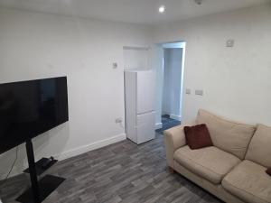 a living room with a couch and a flat screen tv at Modern 1-Bed in Wolverhampton City Centre in Wolverhampton