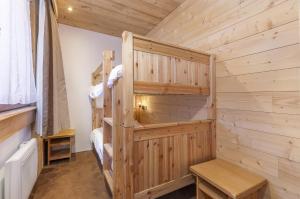 a log cabin bedroom with bunk beds in it at Résidence Les Chalets du Forum - Courchevel 1850 in Courchevel
