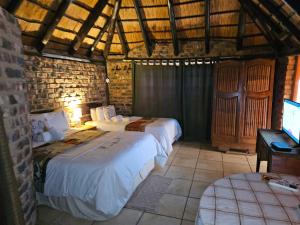a bedroom with two beds and a tv in it at Die Kliphuisie Gastehuis in Vryburg