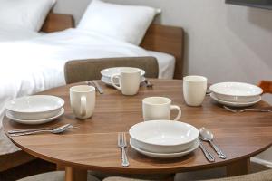a wooden table with plates and utensils on it at The Top名駅 in Nagoya
