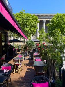 a patio with tables and chairs with the eiffel tower in the background at Fauchon l'Hôtel Paris in Paris
