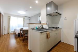 a kitchen with a sink and a bedroom with a bed at The Top名駅 in Nagoya