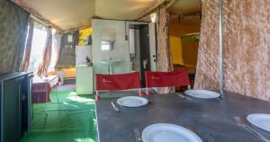 a room with a table with plates and red chairs at Glamlodge Ameland direct aan het strand in Nes +7 photos