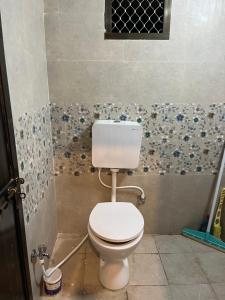 a bathroom with a white toilet in a room at Shiv ghar Stay in Varanasi