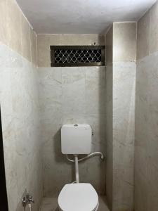 a bathroom with a white toilet in a room at Shiv ghar Stay in Varanasi
