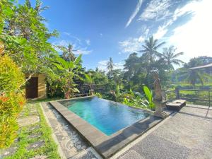 a swimming pool in front of a villa at The Oding House in Ubud