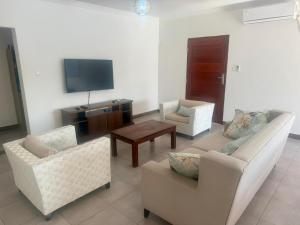 a living room with two couches and a tv at Ponta Rest House in Lopes