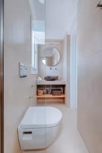 a white bathroom with a toilet and a mirror at Casa View in Akrotiri +50 photos