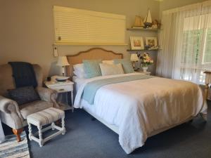 a bedroom with a large bed and a chair at Birchwood Gardens Bed and Breakfast in Narrikup
