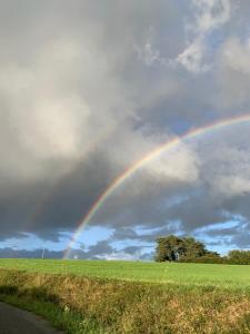 a rainbow in the sky over a field at Serenane in Saint-André-de-Najac