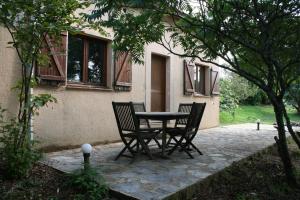 a patio with two chairs and a table in front of a house at Serenane in Saint-André-de-Najac