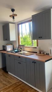 a kitchen with gray cabinets and a sink and a window at Laguna Turawa in Turawa