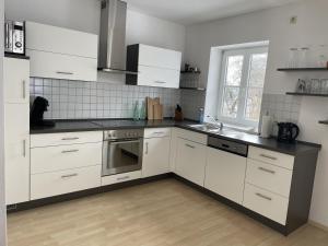 a kitchen with white cabinets and a window at Maisonette Giggi in Peiting +19 photos