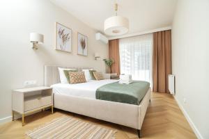 a bedroom with a large white bed and a window at Sand Boho Harmony Luxury - AC Parking & Balcony - by UniqueRent in Wrocław