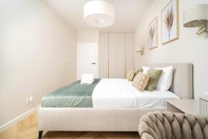 a white bedroom with a large bed and a chair at Sand Boho Harmony Luxury - AC Parking & Balcony - by UniqueRent in Wrocław +38 photos