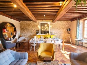 a restaurant with tables and chairs and a brick wall at Jardin des Sens, la Rente d'Eguilly in Éguilly
