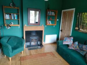 a living room with a couch and a fireplace at Hidden Hearts Haven Spa in Lelagh