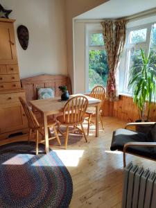 a dining room with a wooden table and chairs at Hidden Hearts Haven Spa in Lelagh