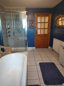 a bathroom with a tub and a shower with a glass door at Hidden Hearts Haven Spa in Lelagh +55 photos