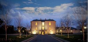 a large white house at night with lights at Hidden Hearts Haven Spa in Lelagh