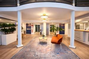 an office lobby with a chair and a table at Séjours & Affaires Bordeaux de L'Yser in Bordeaux