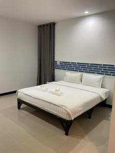 a large bed with white sheets and pillows on it at โรงแรมช้างใหญ่ใจดี in Yasothon