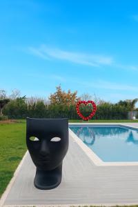 a black mask sitting next to a swimming pool at Hotel Ohana in Rome