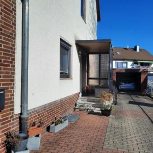 a house with a brick walkway next to a building at Farbenfrohe Dachgeschoßwohnung in Giesen