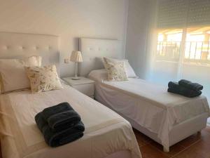 a bedroom with two beds with towels on them at Enjoy Toledo, junto a Puy du Fou in Argés +24 photos