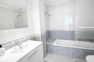 a white bathroom with a tub and a sink at Casa Vacacional El Alisu in Arriondas +14 photos
