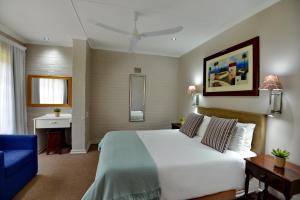 a bedroom with a large white bed and a blue couch at Baywater Village by MyResorts in Sedgefield