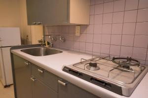 a kitchen with a stove and a sink at Hotel Listel Hamanako in Hamamatsu +8 photos