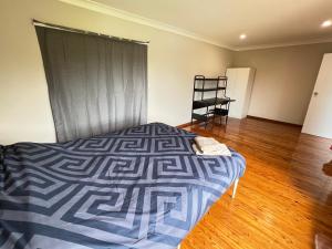 a bedroom with a bed and a wooden floor at Room 44 in Baulkham Hills