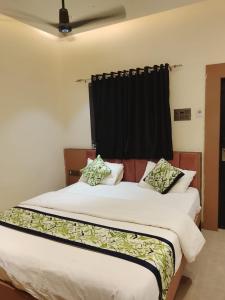 a bedroom with two beds and a black curtain at Hotel Gurudev Inn in Junnar