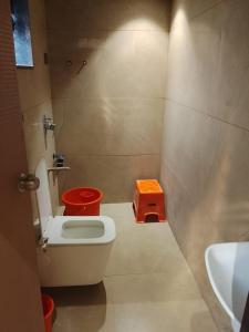 a small bathroom with a toilet and a sink at Hotel Gurudev Inn in Junnar