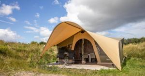 a tent in the middle of a field at Duynlodge Ameland direct aan het strand in Nes