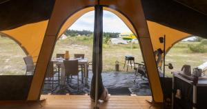 a view of a tent with a table and chairs at Duynlodge Ameland direct aan het strand in Nes