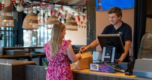 a man and a woman standing at a cash register at Duynlodge Ameland direct aan het strand in Nes