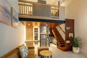 a living room with a couch and a staircase at The New Moon Umalas in Seminyak