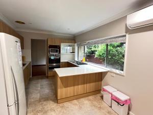 a kitchen with a white refrigerator and a window at Room 00 in Baulkham Hills