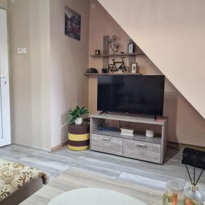 a living room with a flat screen tv on a entertainment center at Square Apartment in Paraćin